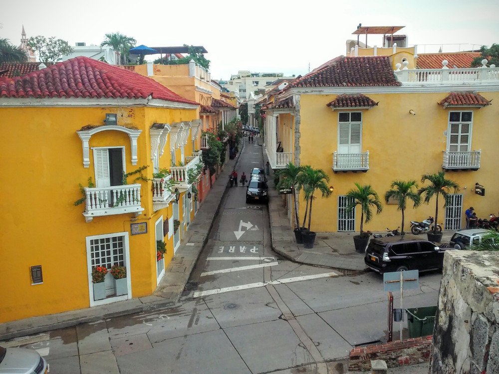 Una calle de la ciudad amurallada de Cartagena con todas sus casas pintadas de amarilla y blanca